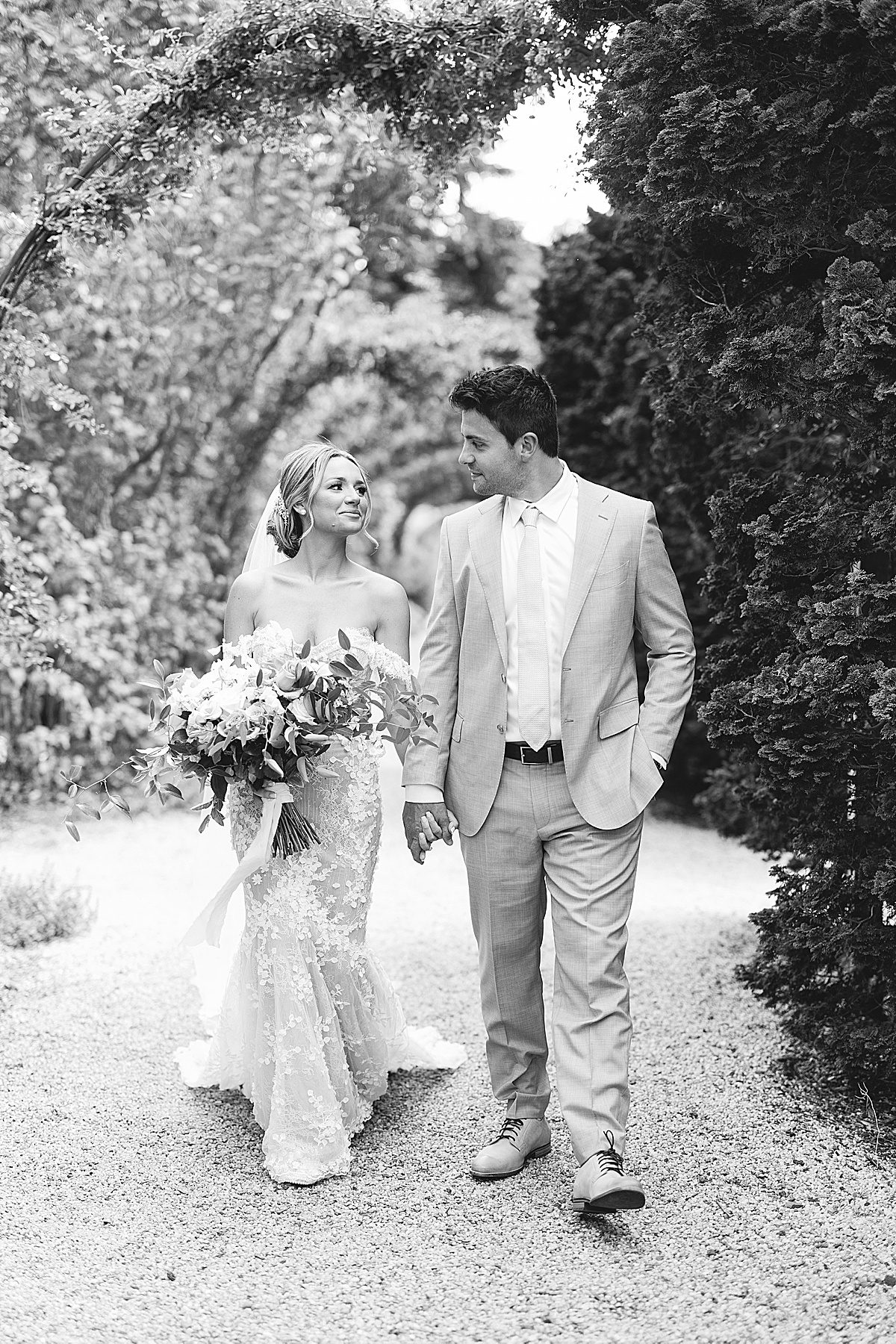 Black and White of Bride and Groom Holding Hands Walking at Planting Fields Arboretum Photo