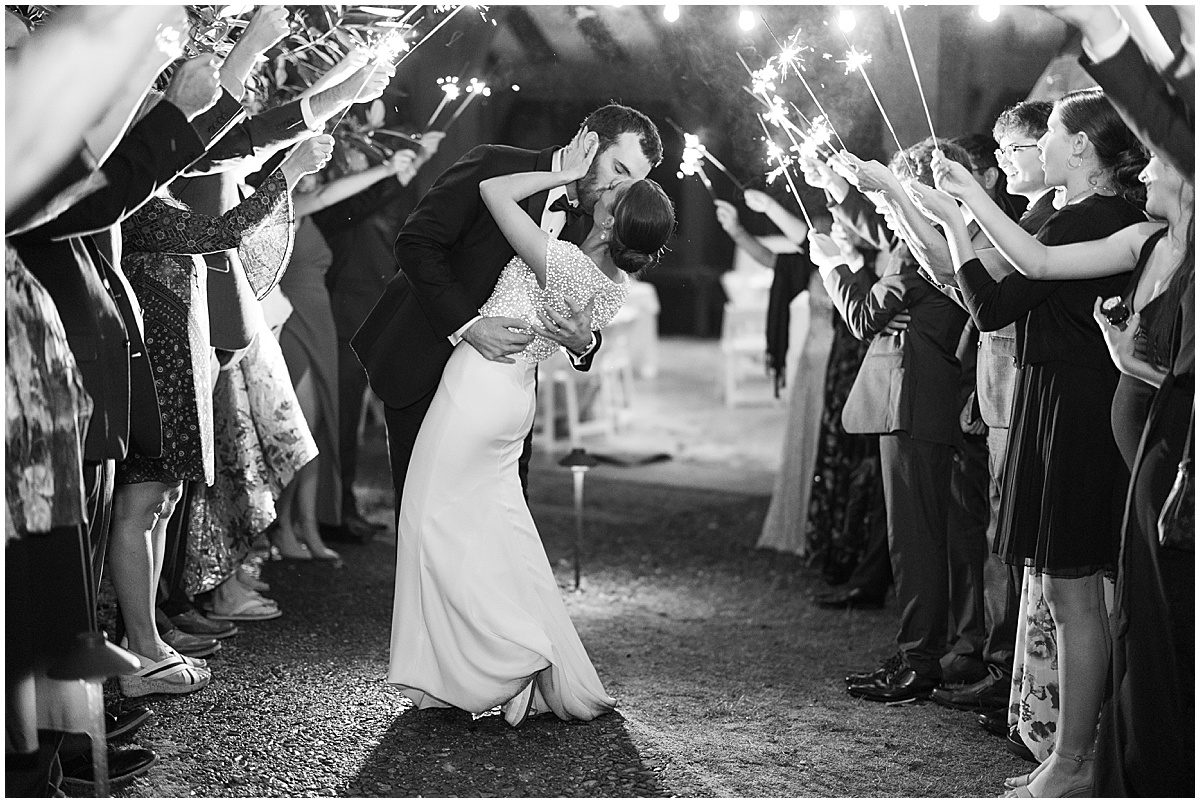 Black and White of Bride and Groom Kissing in Sparkler Exit Photo