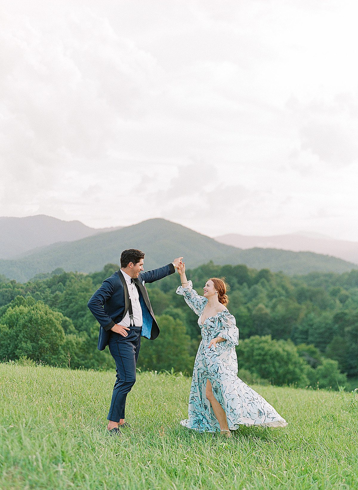 Artistic Asheville Wedding Photographer Captures Bride and Groom Dancing in Filed Photo