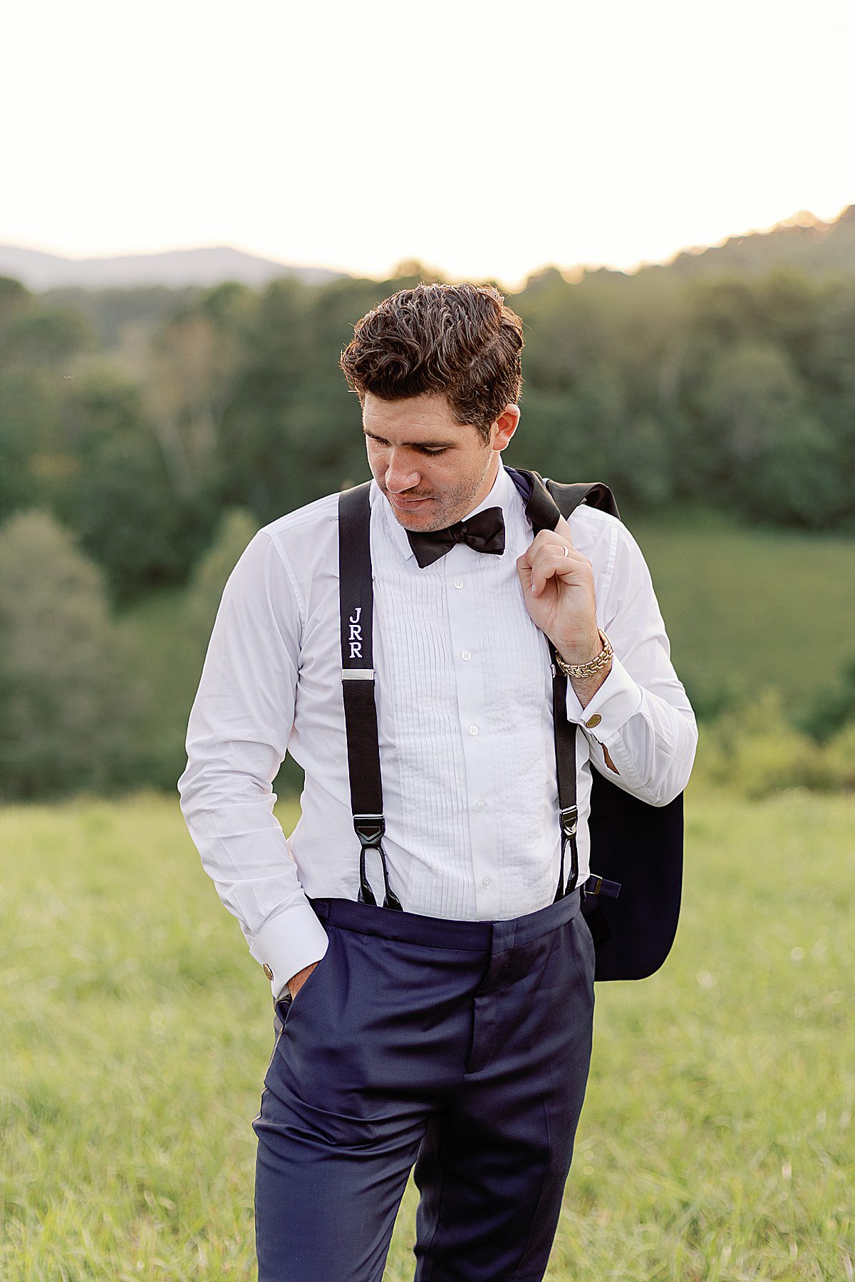 The Ridge Asheville Wedding Venue Groom Looking Down with Jacket Over Shoulder photo