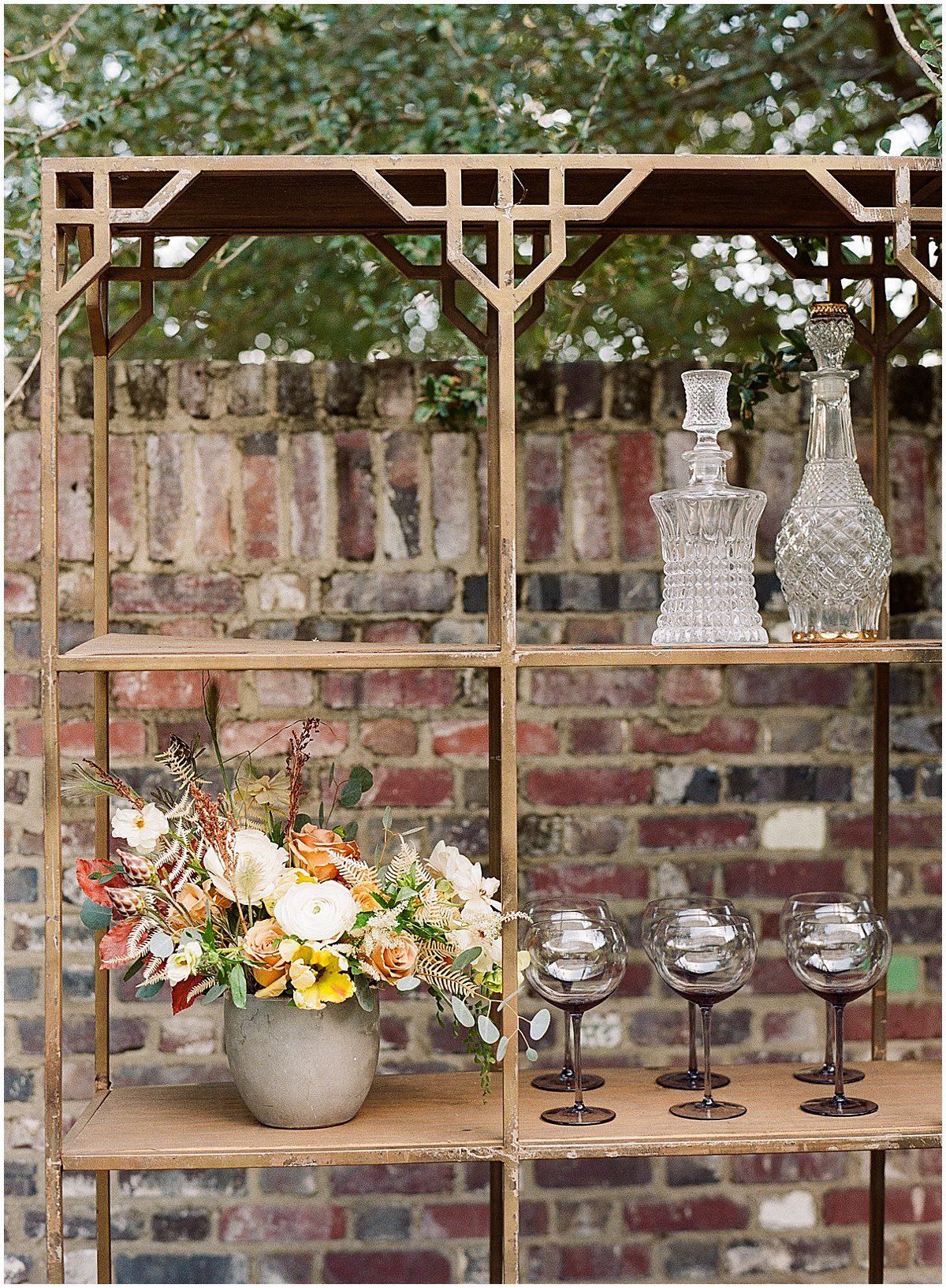 Gold Metal Shelf with Wine Glasses and Flowers Photo