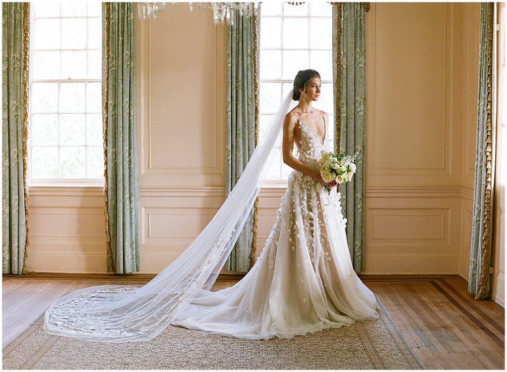 Bride Holding Flowers Looking Out Window at Lowndes Grove Photo