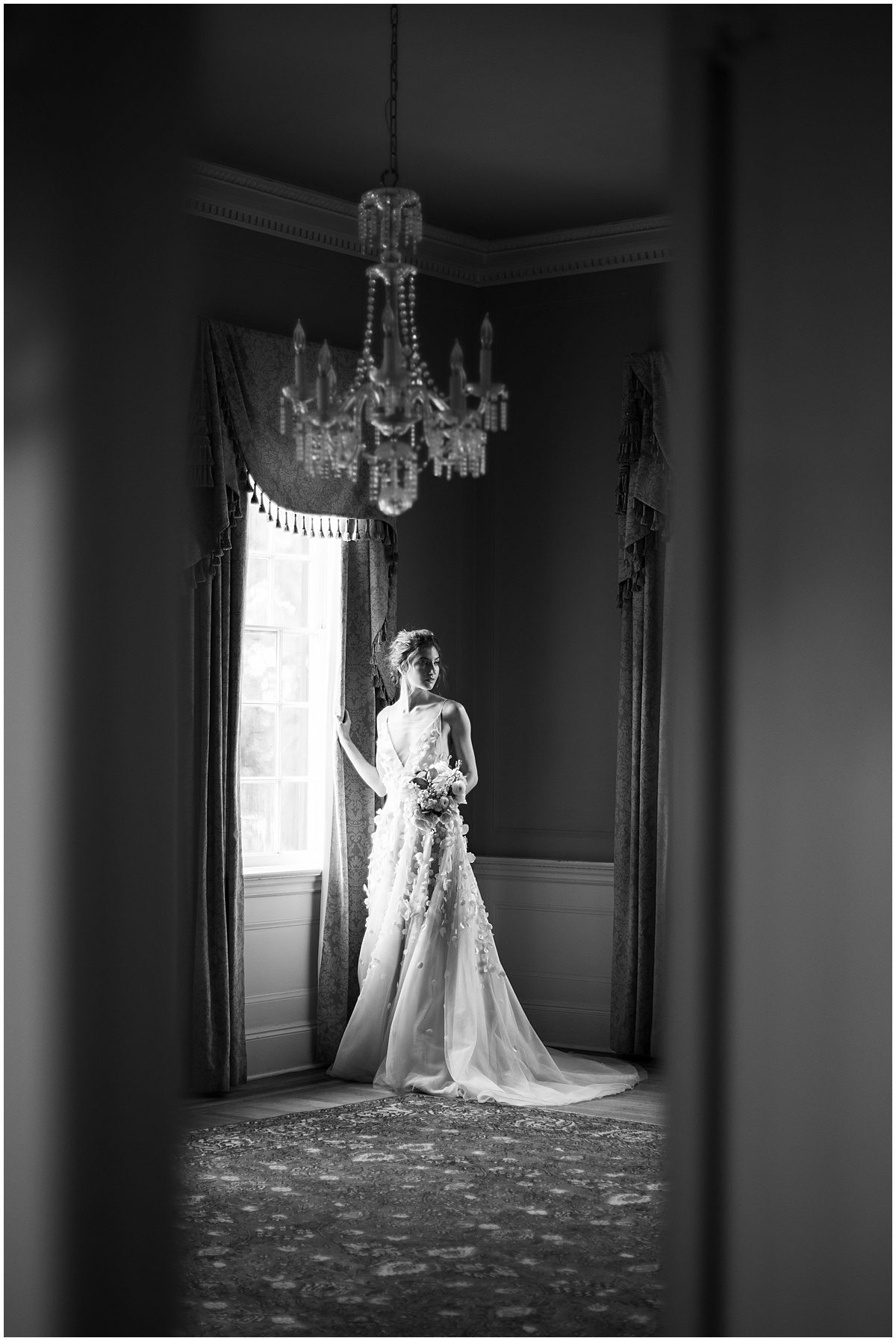 Black and White of Bride Standing By Window at Lowndes Grove Wedding Venue Photo