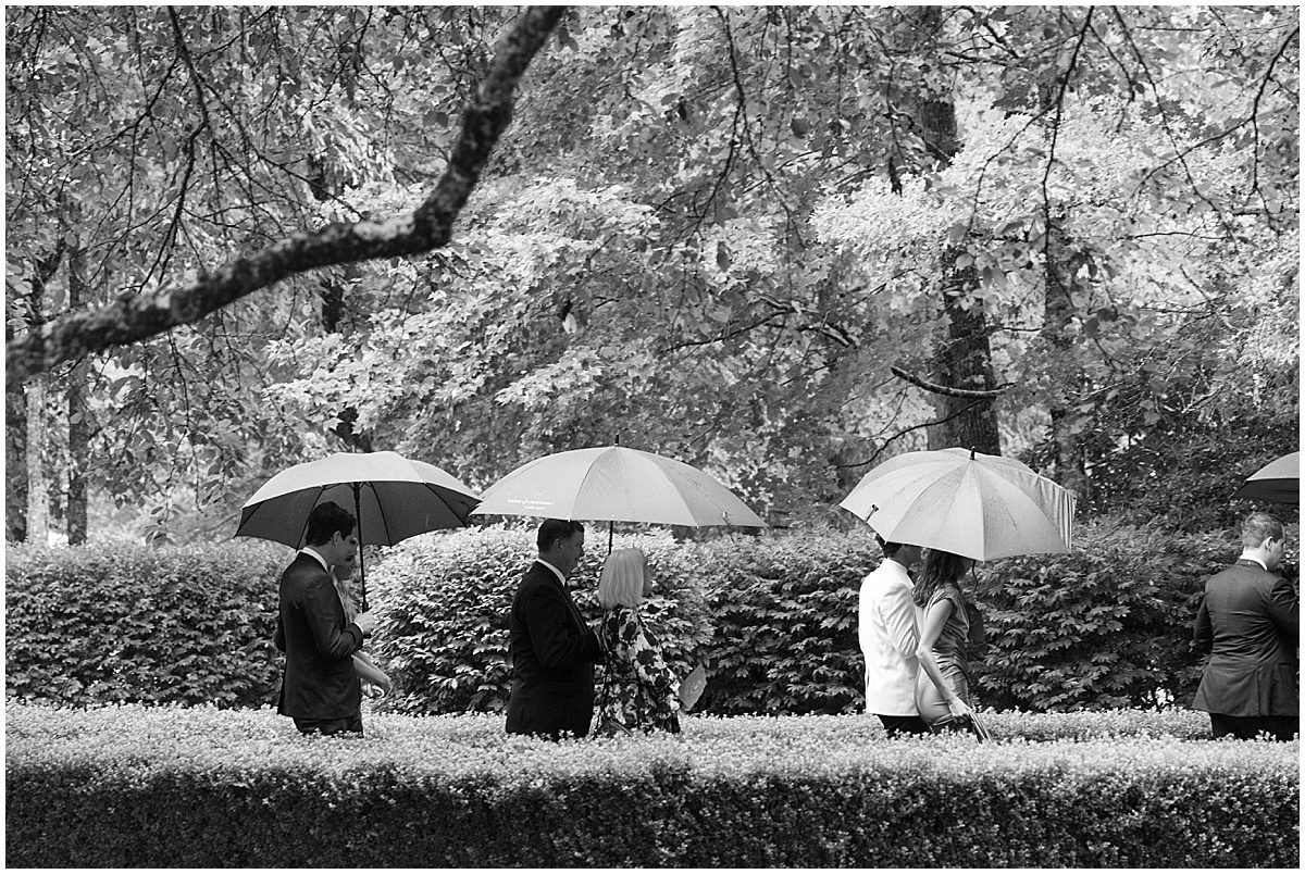 Black and White of Wedding Guests Walking in the Rain Photo