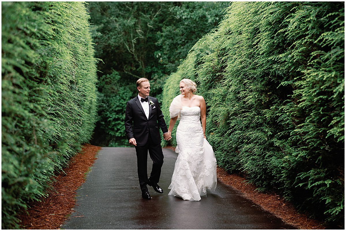 Bride and Groom Holding Hands Walking In Trees Photo