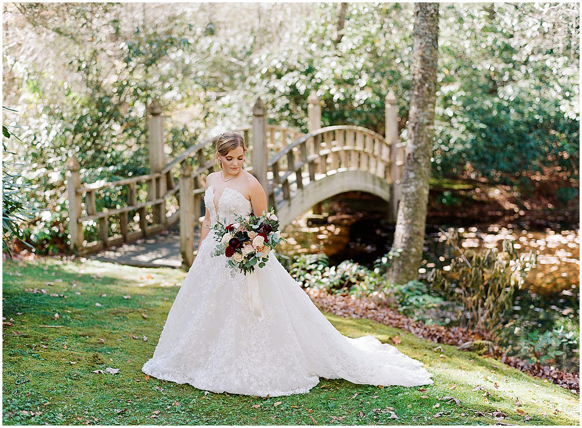 Bride Holding Bouquet In Front of Bridge at The Farm at Old Edwards Inn Photo