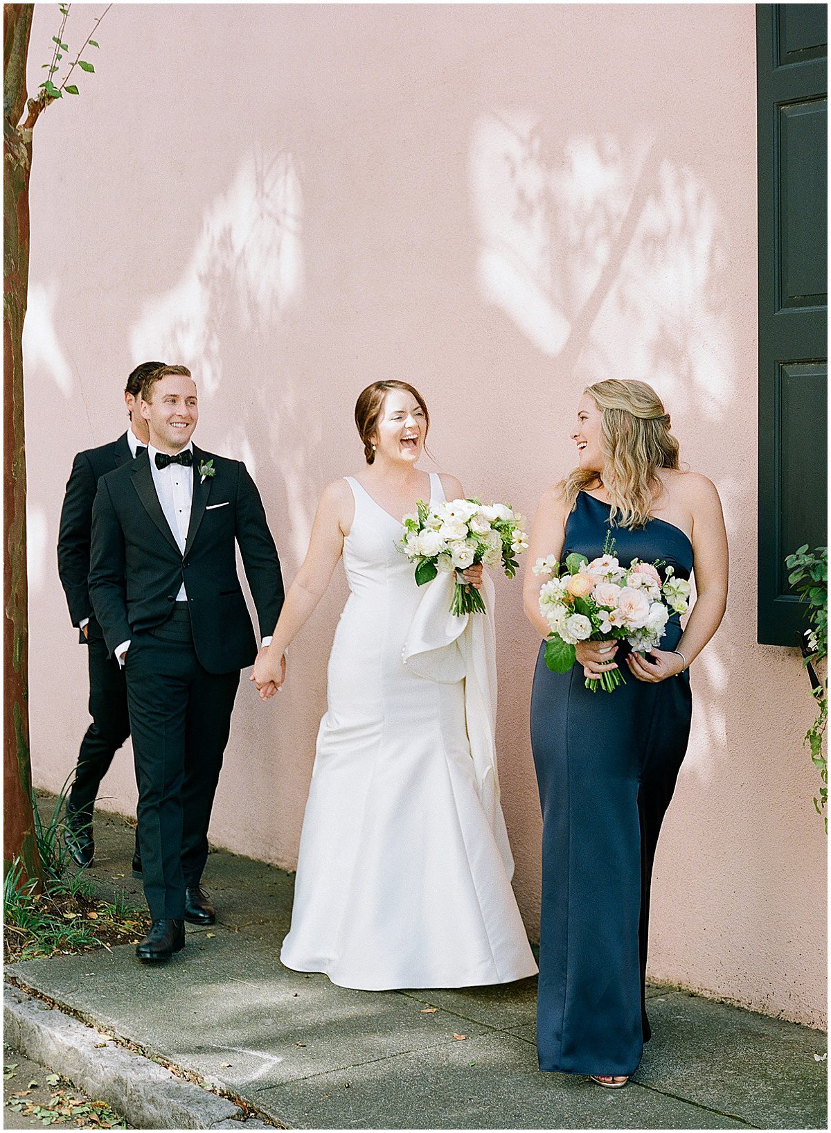 Bride Holding Grooms Hand Laughing at Sister Photo