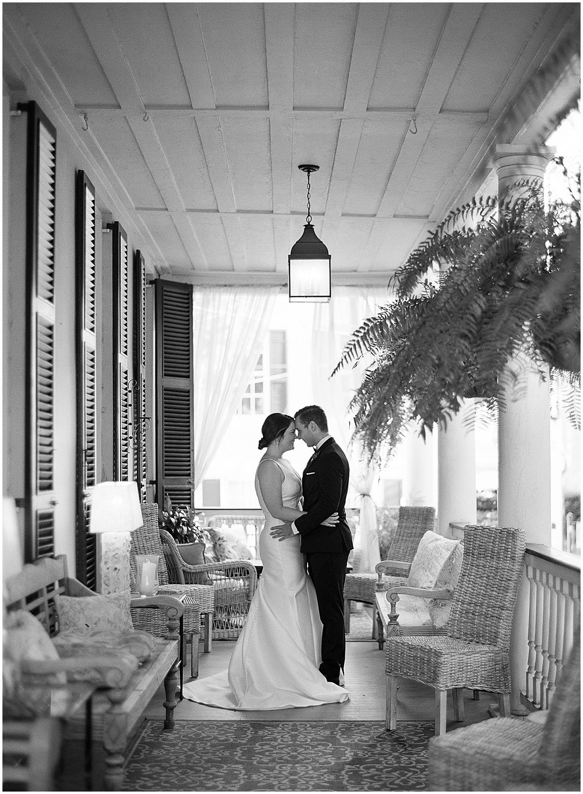Black and White of Bride and Groom Nose to Nose On Porch of The Parsonage in Charleston SC Photo