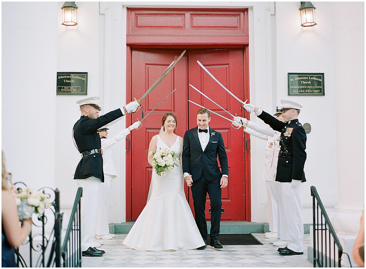Bride and Groom Exiting Church After Ceremony Under Sword Arch Photo