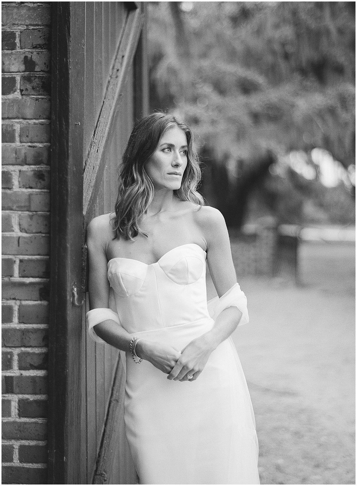 Black and White of Bride Leaning against Wall Photo