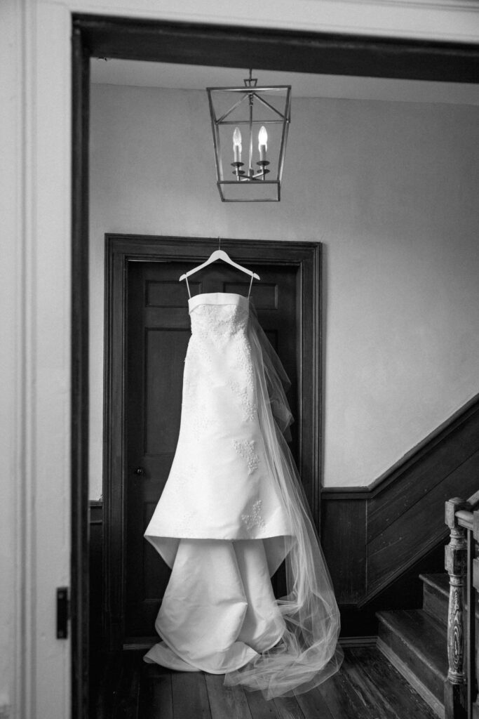 Black and White of wedding gown hanging on door frame photo