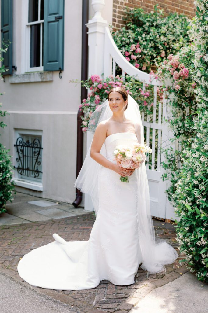 Bride in front of wisteria covered gate photo