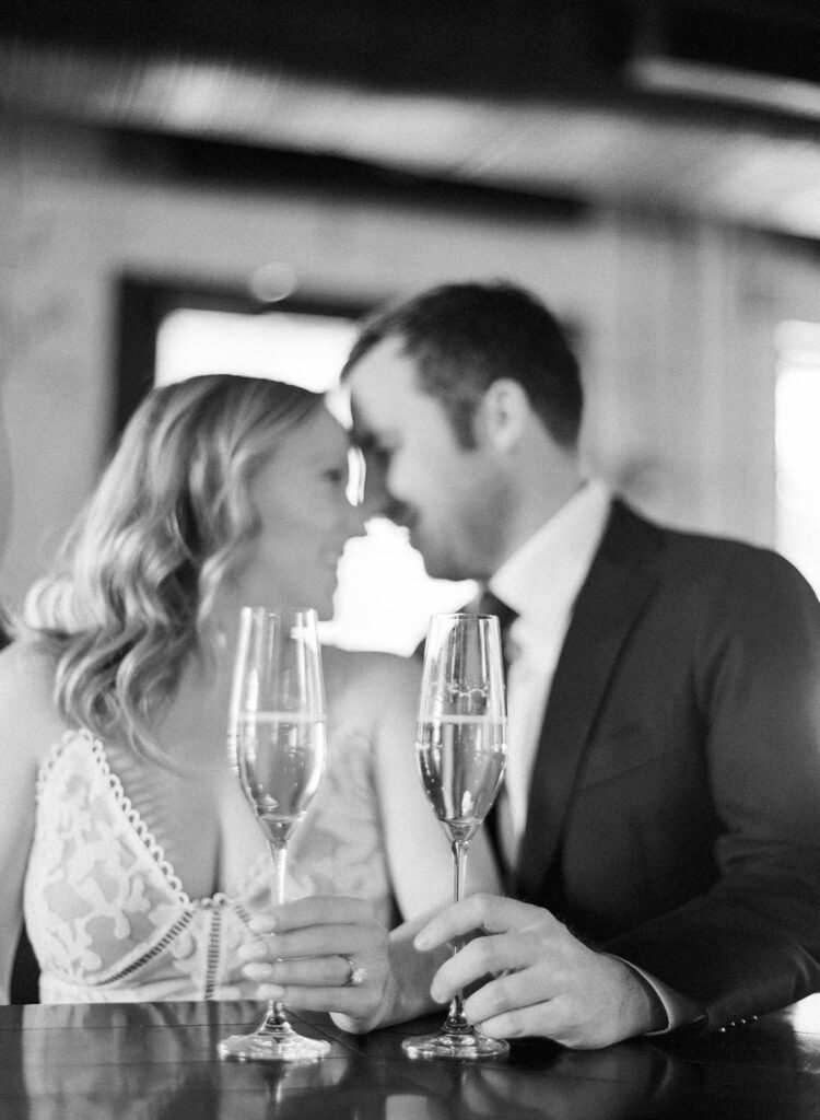 couple nose to nose holding champagne glasses