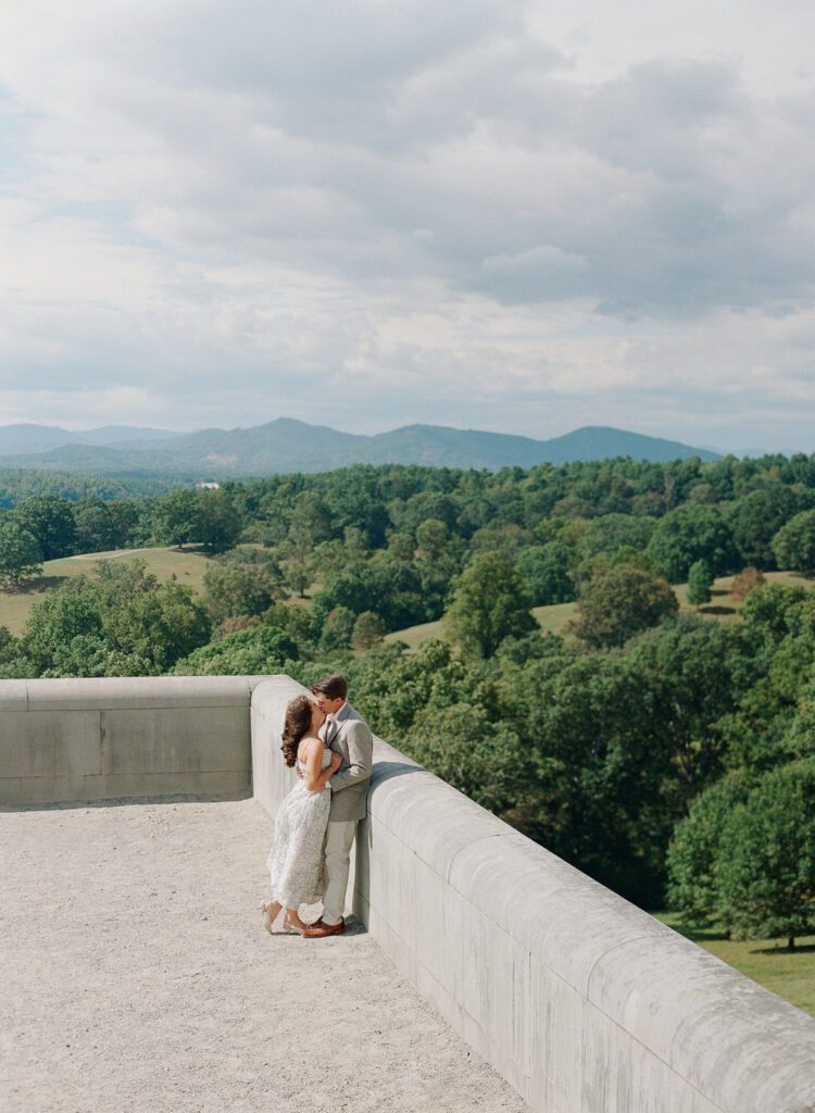 Couple kissing on terrace with mountains in background