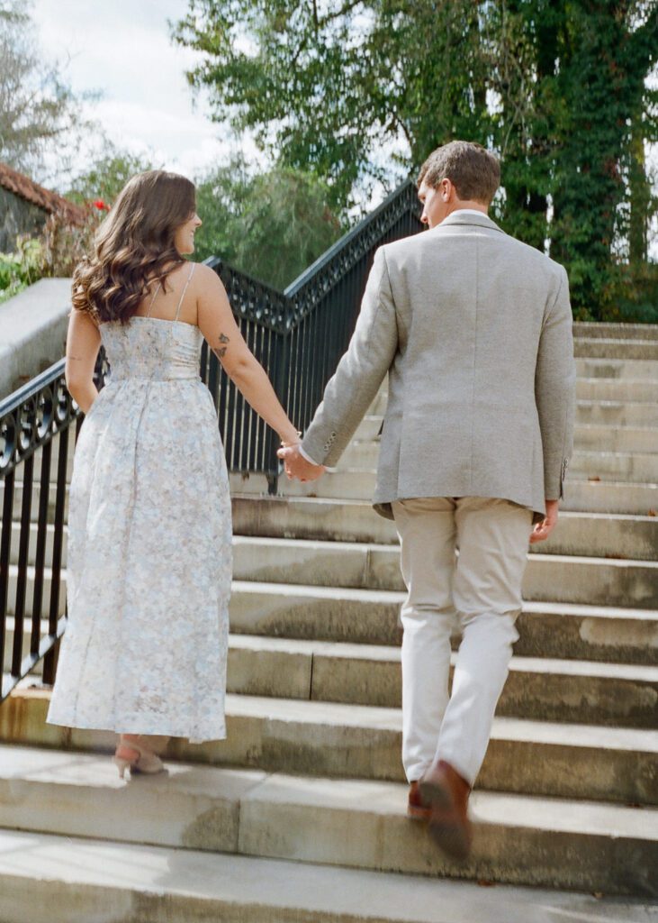 couple holding hands walking up stairs