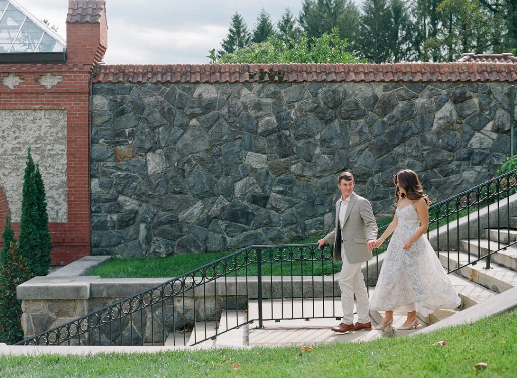 couple holding hands walking down stairs