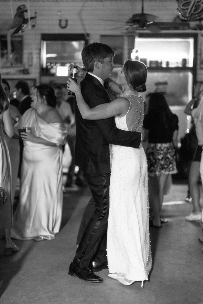 black and white of bride and groom dancing 