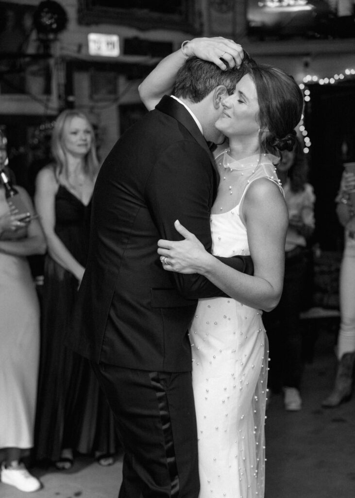 black and white of bride and groom dancing 