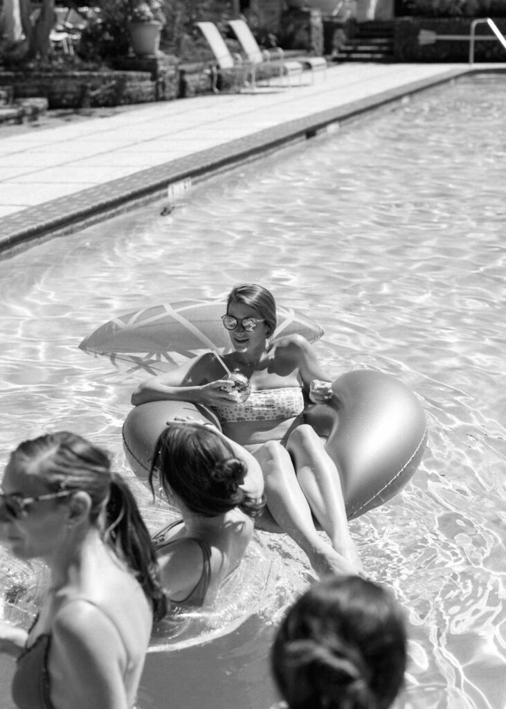 black and white of bride in pool float 