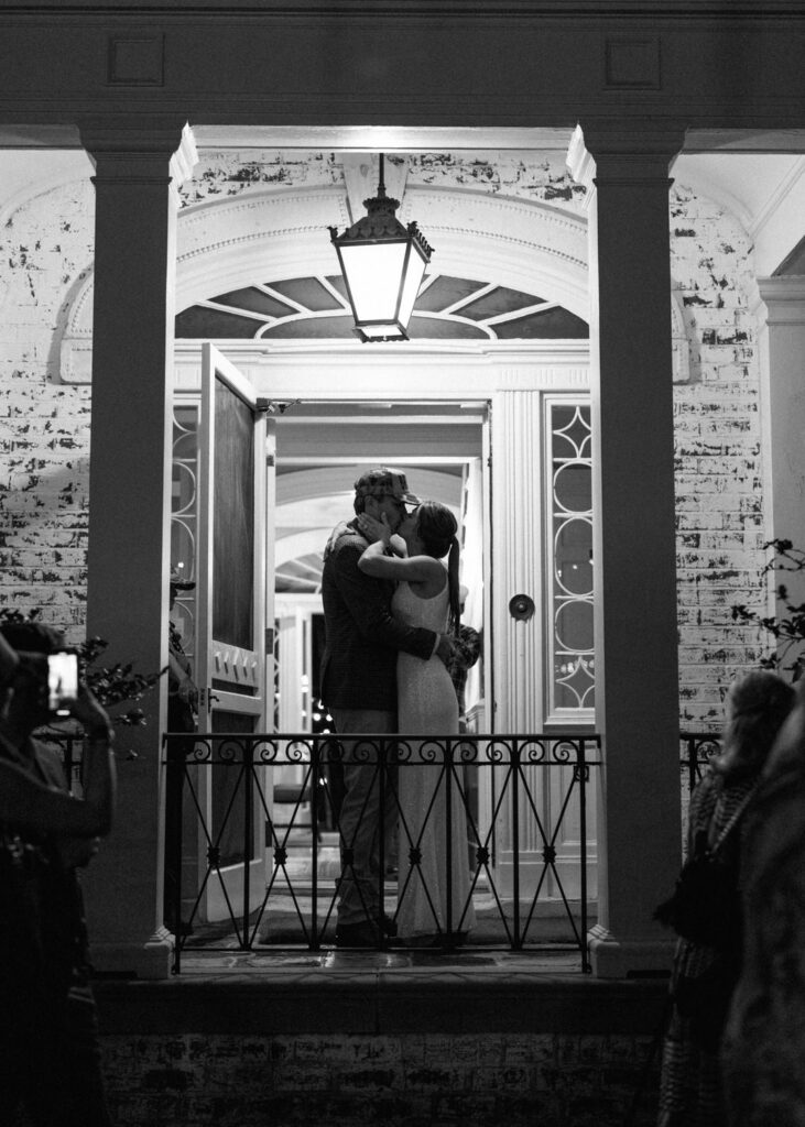 black and white of bride and groom kissing 