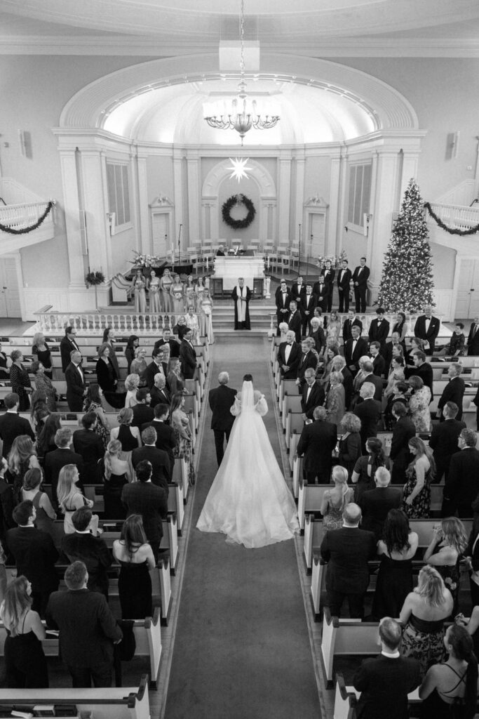 Bride and Father of the bride walking down church aisle during wedding ceremony