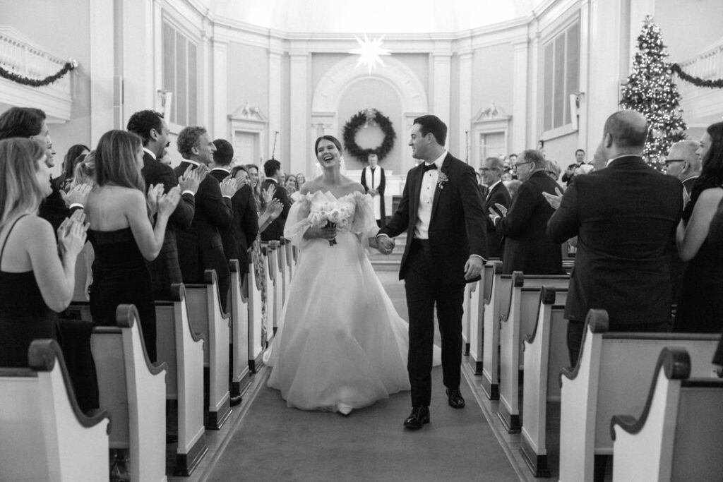 Black and White of bride and Groom exiting ceremony laughing