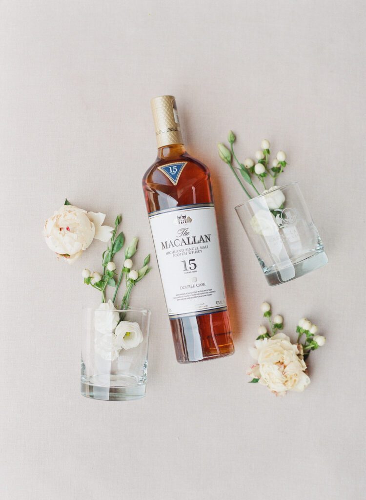 bottle of Macallan whiskey with glasses and flowers