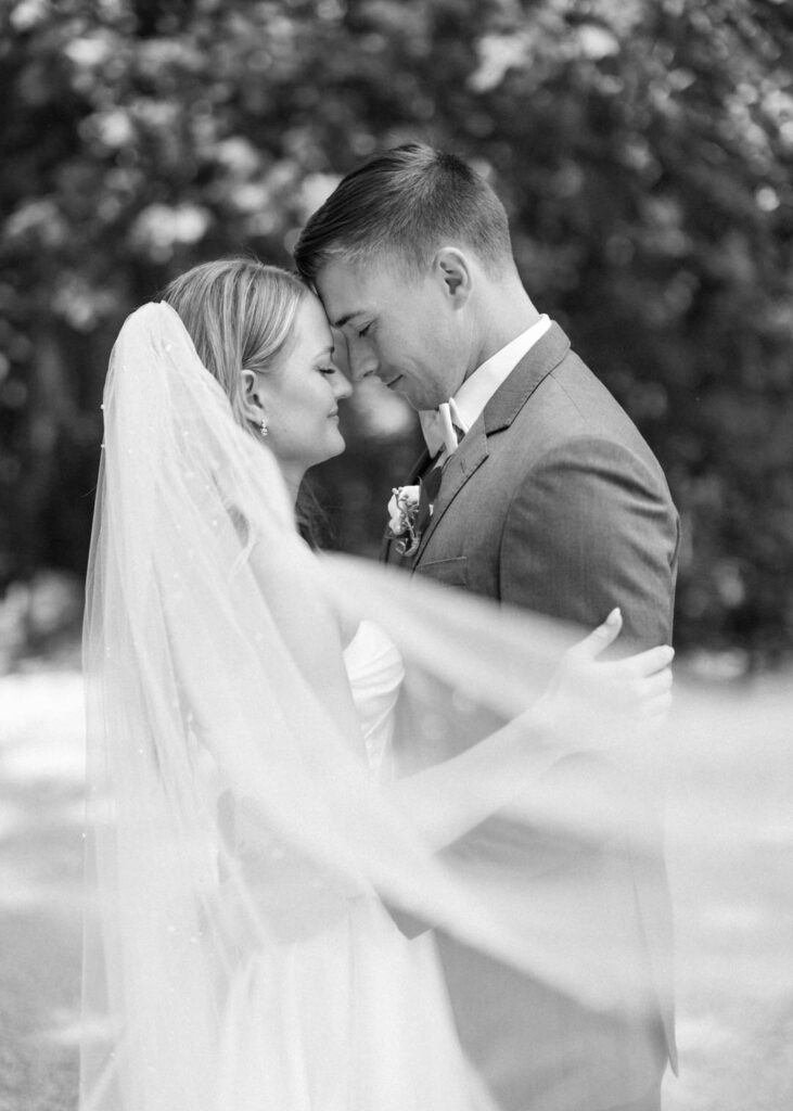 black and white of bride and groom nose to nose