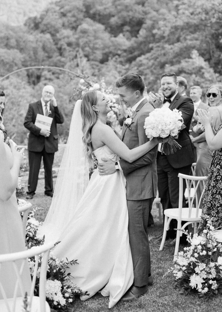 black and white of bride and groom laughing after ceremony