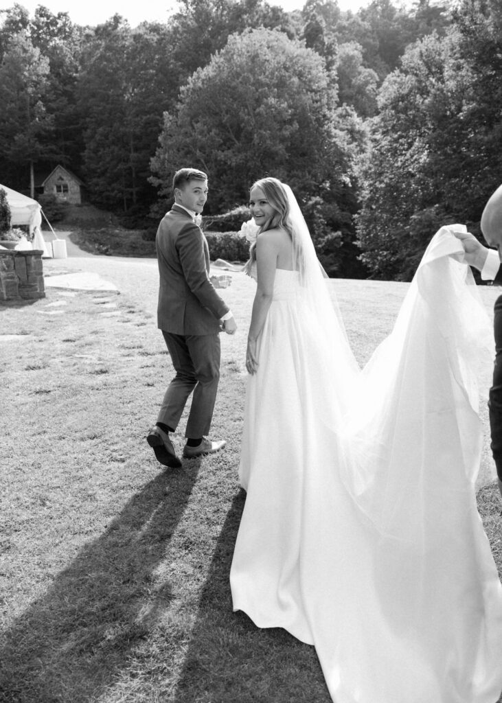 black and white of bride and groom walking