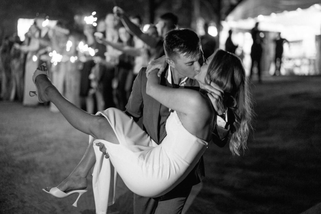 black and white of bride and groom kissing