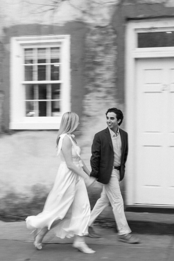 Black and white motion blur photo of couple walking on sidewalk