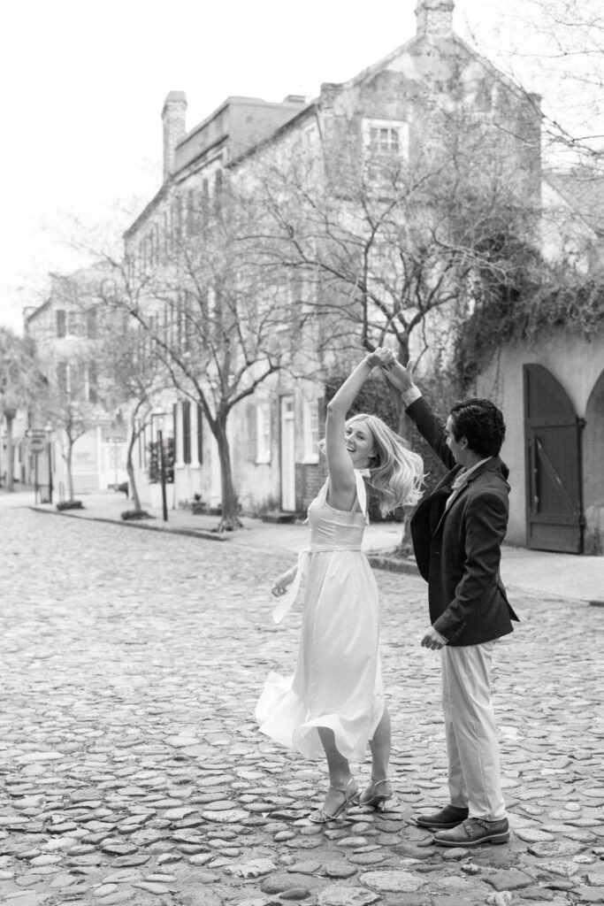 black and white of couple dancing on cobblestone street