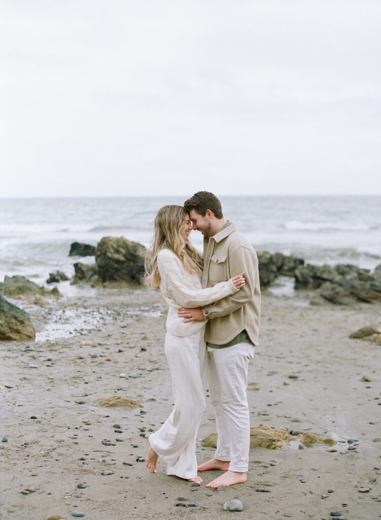 El Matador Beach Photos of couple nose to nose hugging and laughing