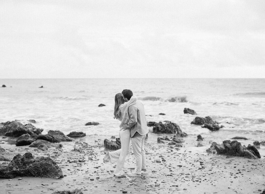 black and white of couple hugging on the beach