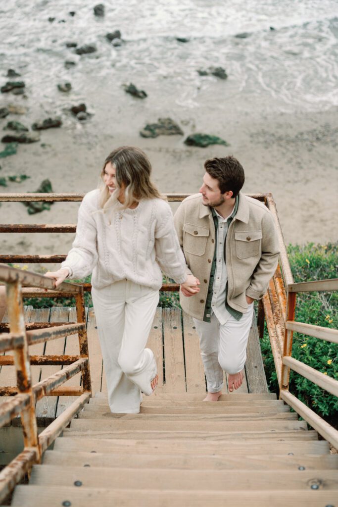 Couple holding hands walking up stairs