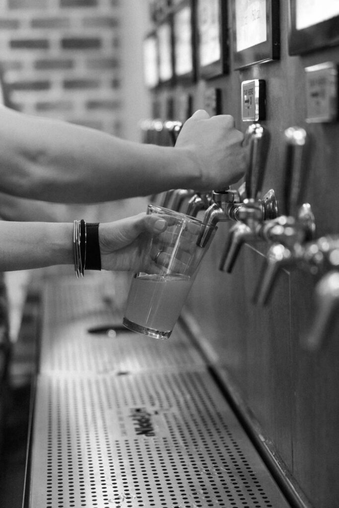 black and white of guest pouring beer