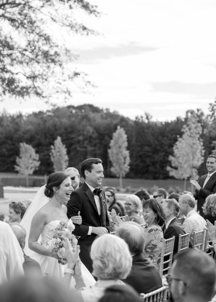 black and white of bride and groom exiting ceremony 