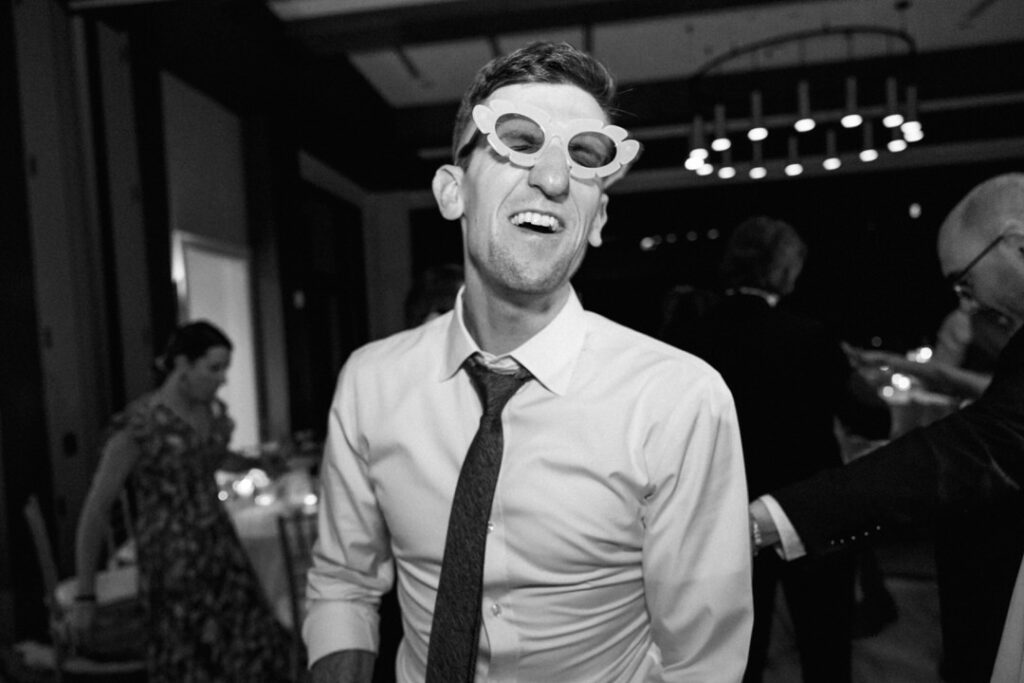 black and white of wedding guest dancing with glasses 