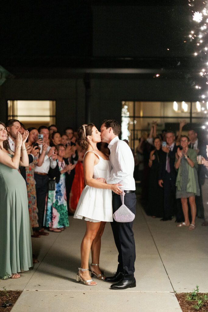 bride and groom kiss with cold sparklers 