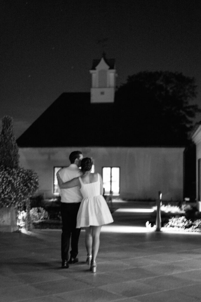 black and white of bride and groom hugging walking 