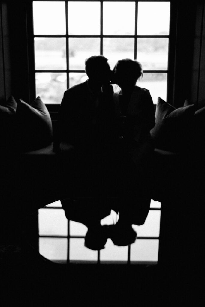 black and white of bride and groom kissing reflection