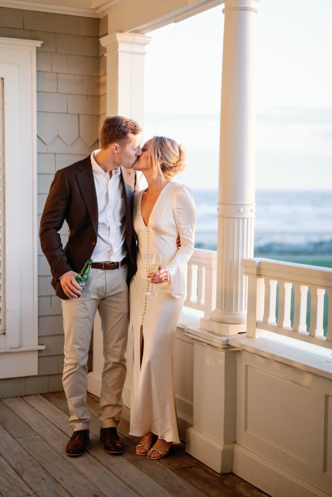 bride and groom kissing on balcony