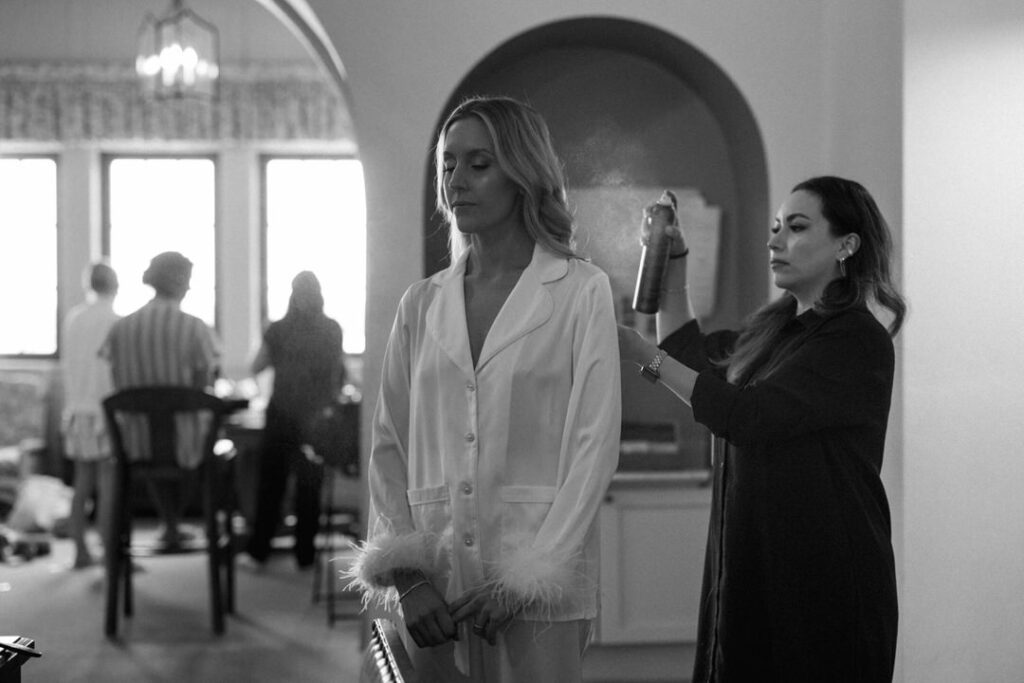 black and white of bride getting hair sprayed