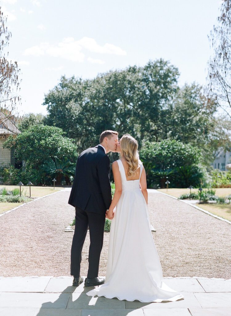 bride and groom kissing holding hands