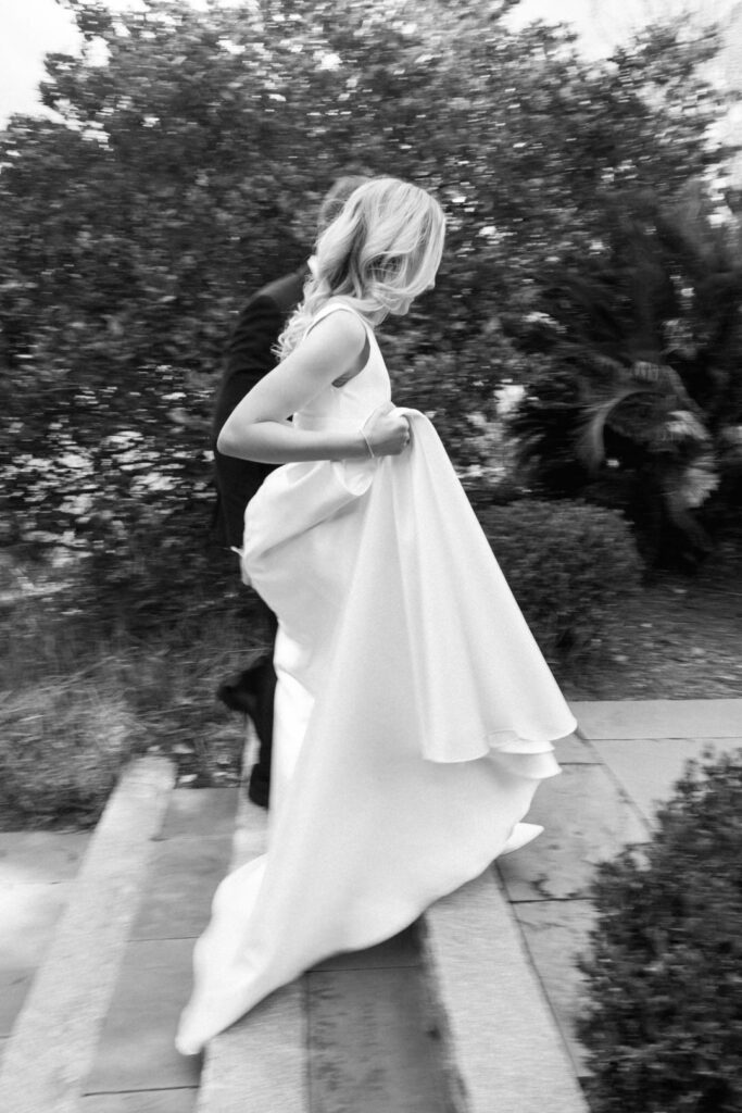 black and white of bride and groom walking up stairs