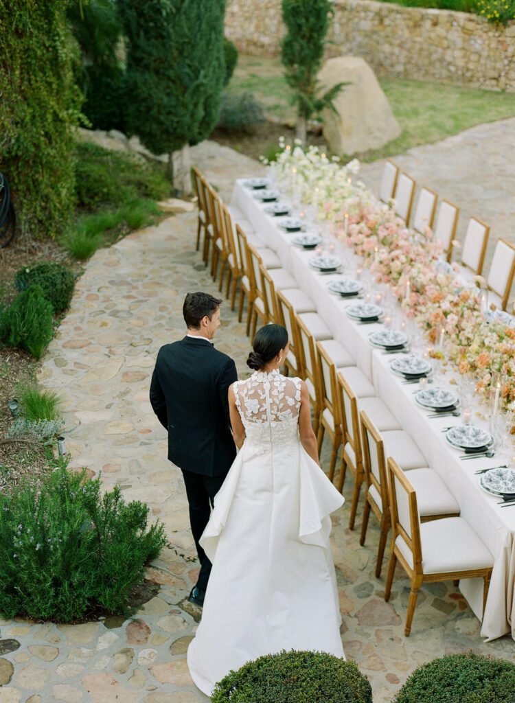 Bride and Groom Walking by Wedding Reception Table 