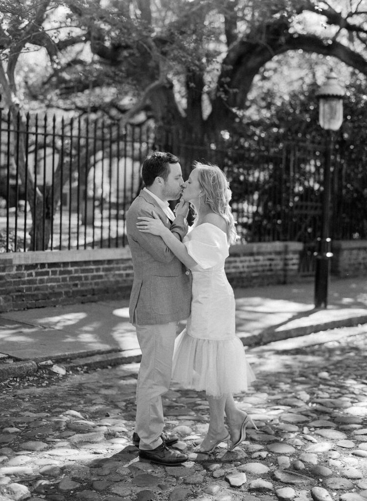 black and white of bride and groom kissing on Chalmers Street in Charleston