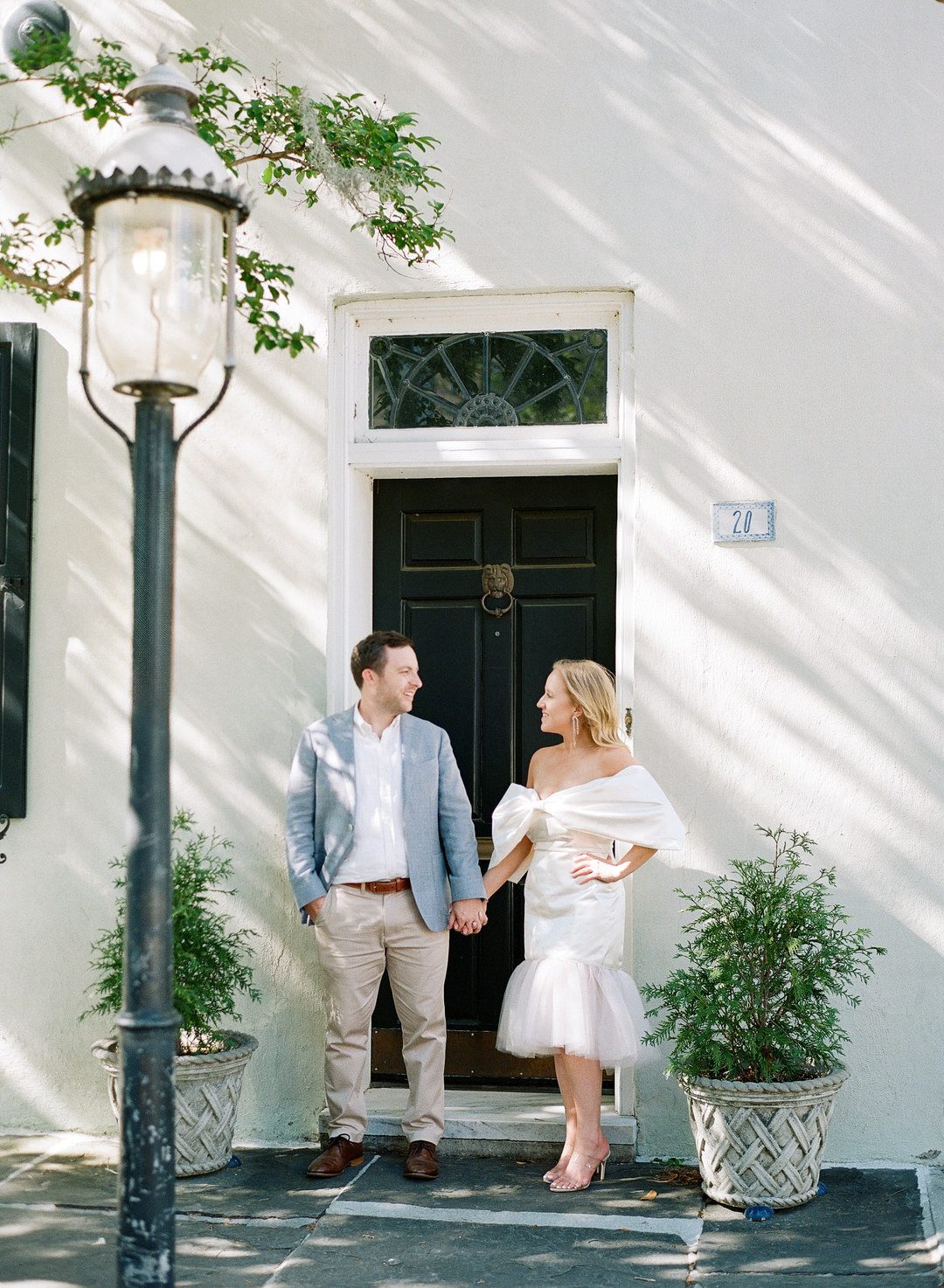 bride and groom holding hands in doorway on Chalmers Street in Charleston