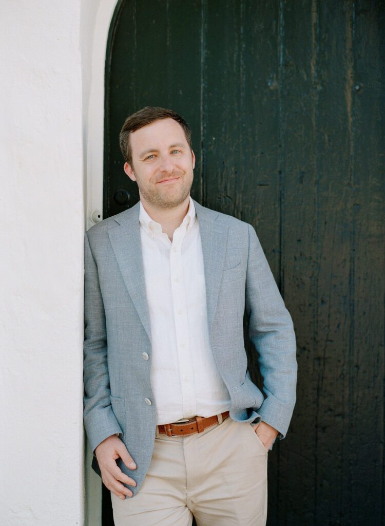 groom in archway smiling at camera